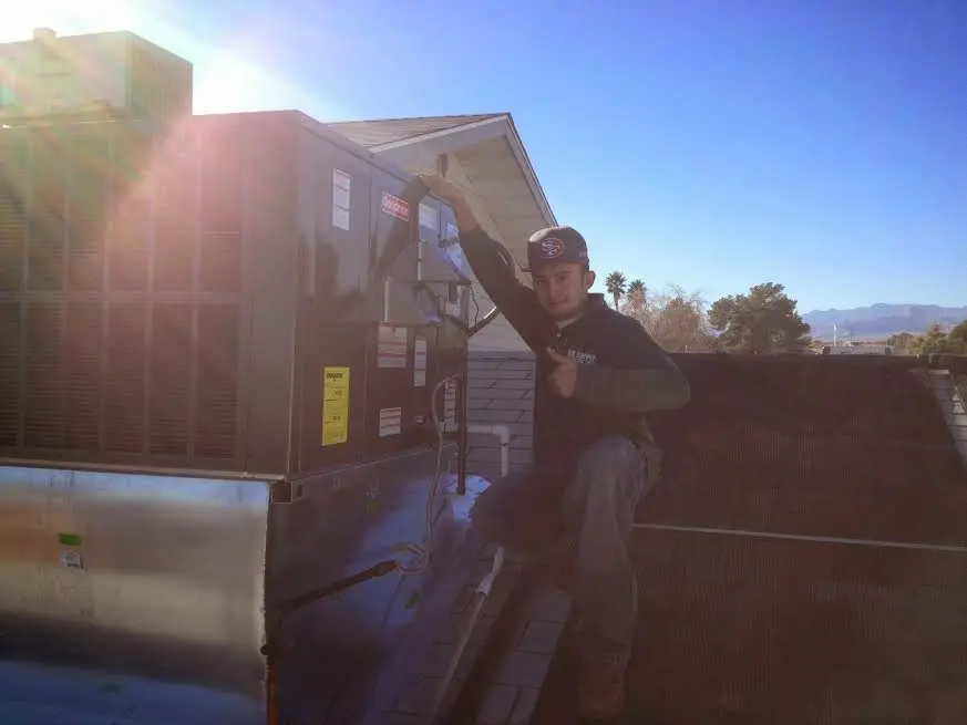 HVAC technician performing AC Tune-Up on a rooftop unit in Overland Park